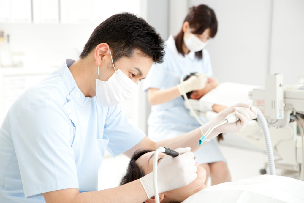 歯科医院で患者を治療する男性医師