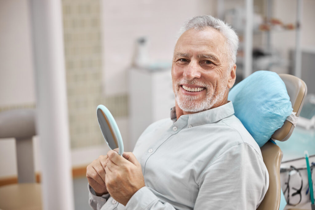 歯科医院で微笑む年老いた男性