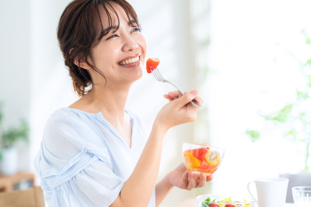 歯周病を治療し笑顔で食事をする女性