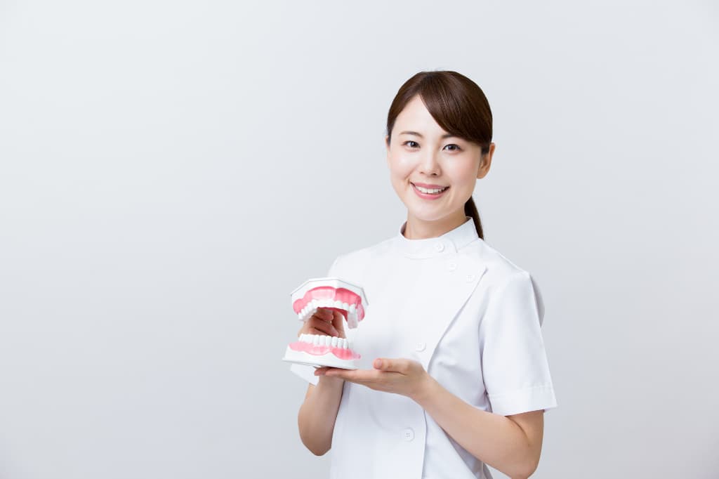 歯科医院の定期健診が重要であると説明する歯科衛生士