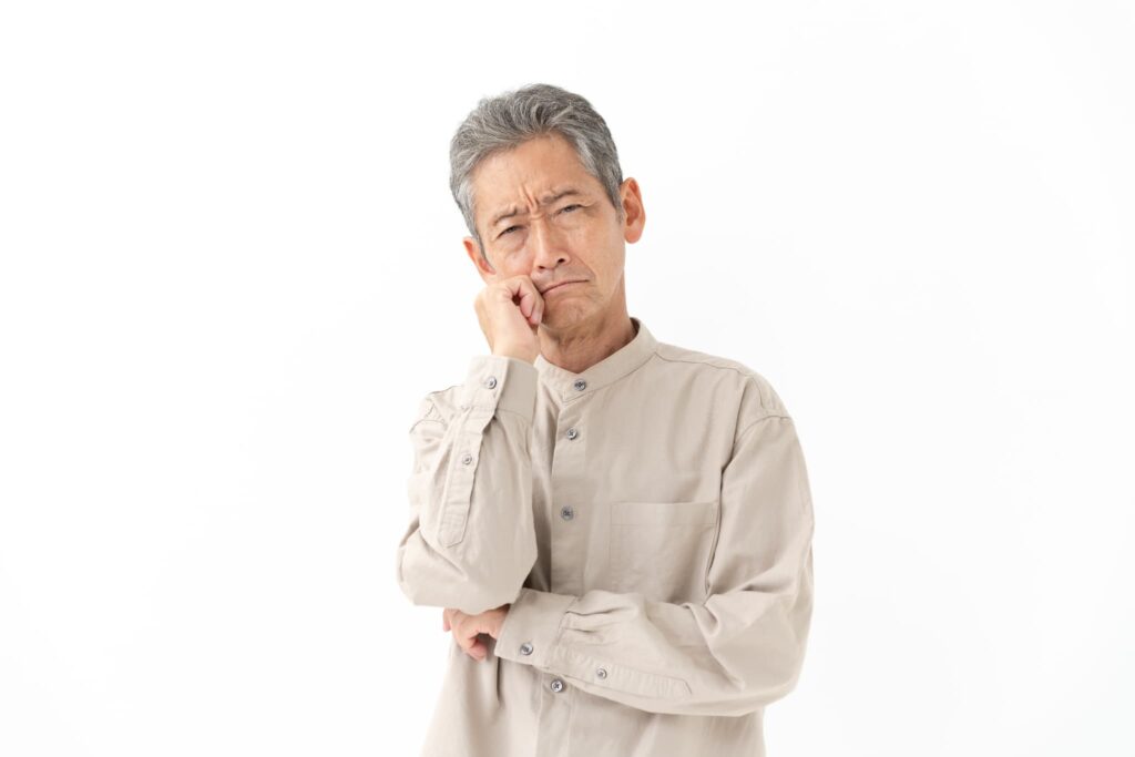 入れ歯が外れるのはどうしてか考える高齢男性