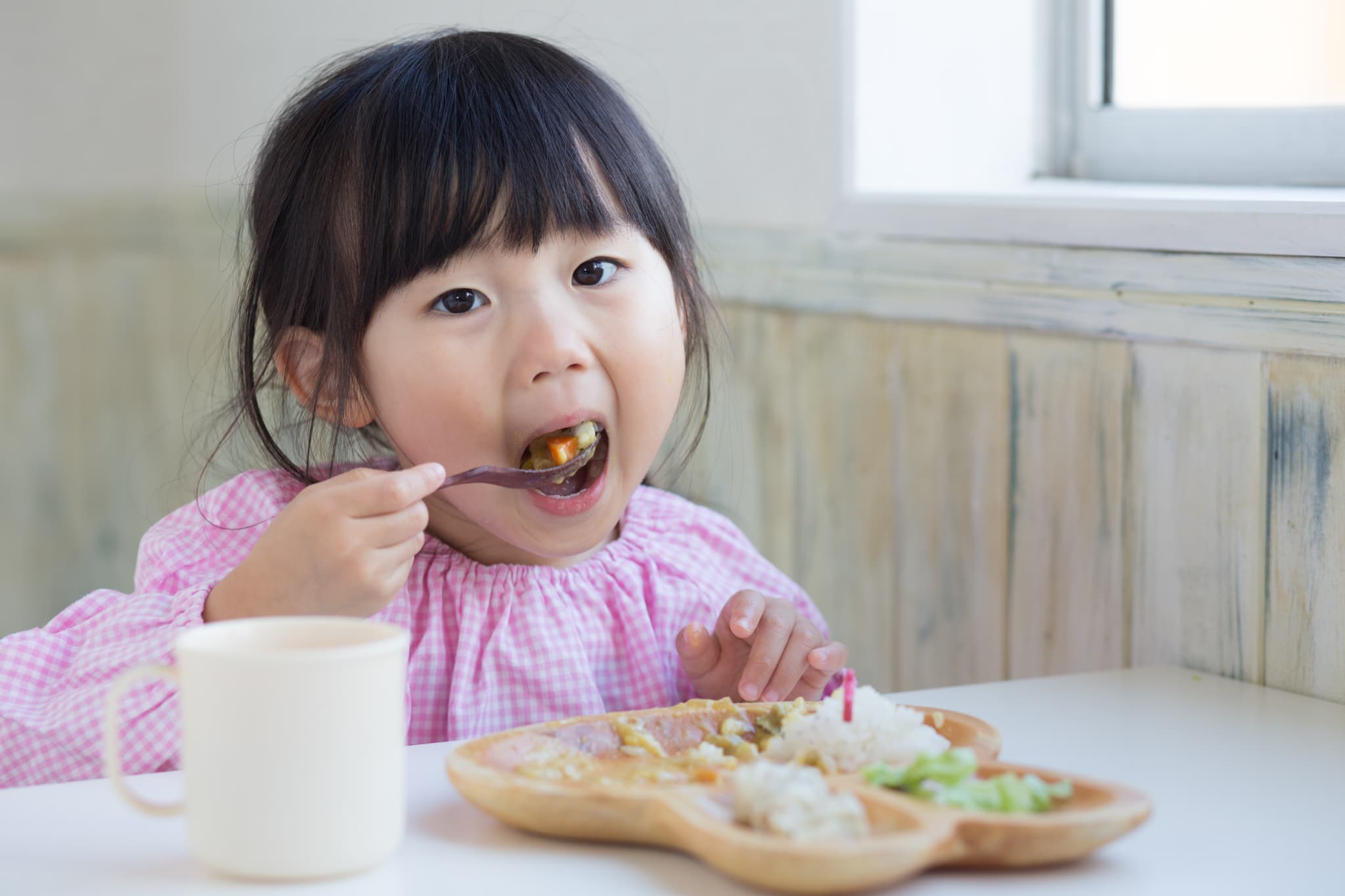 歯並びが悪くなるのを防ぐためによく噛んで食事をする女の子