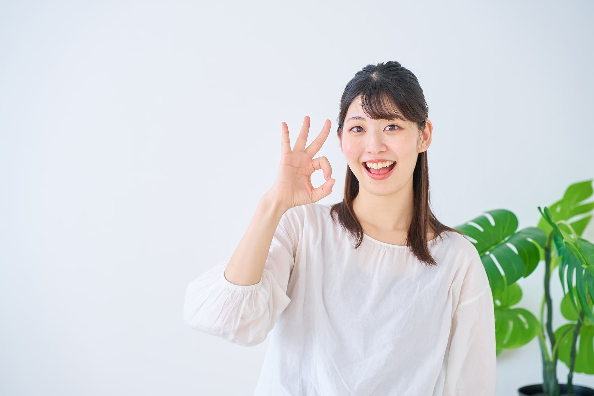 埋まっていた親知らずを抜歯してOKサインを出す女性