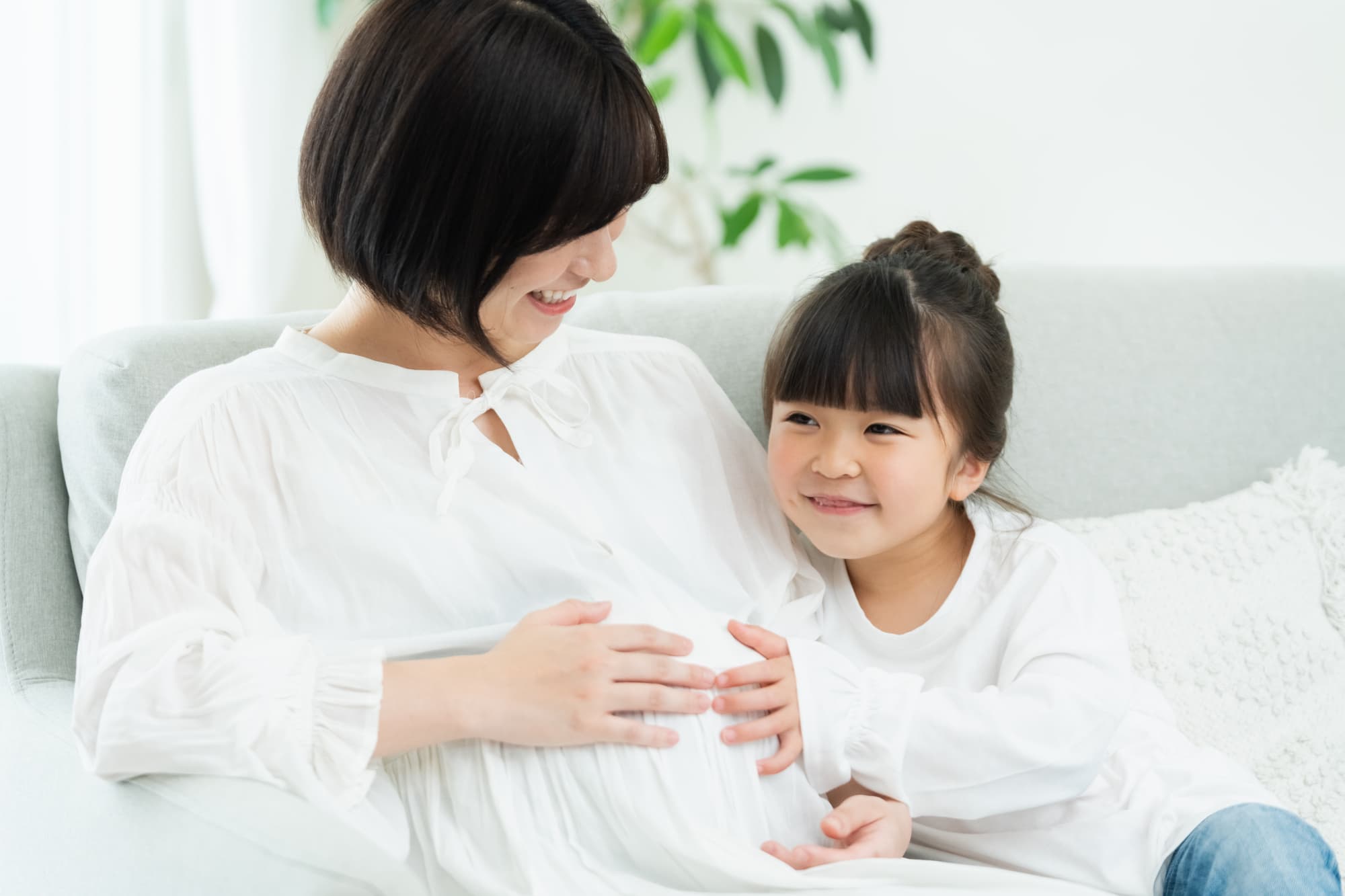 妊娠中の母親とお腹に手を添える子ども