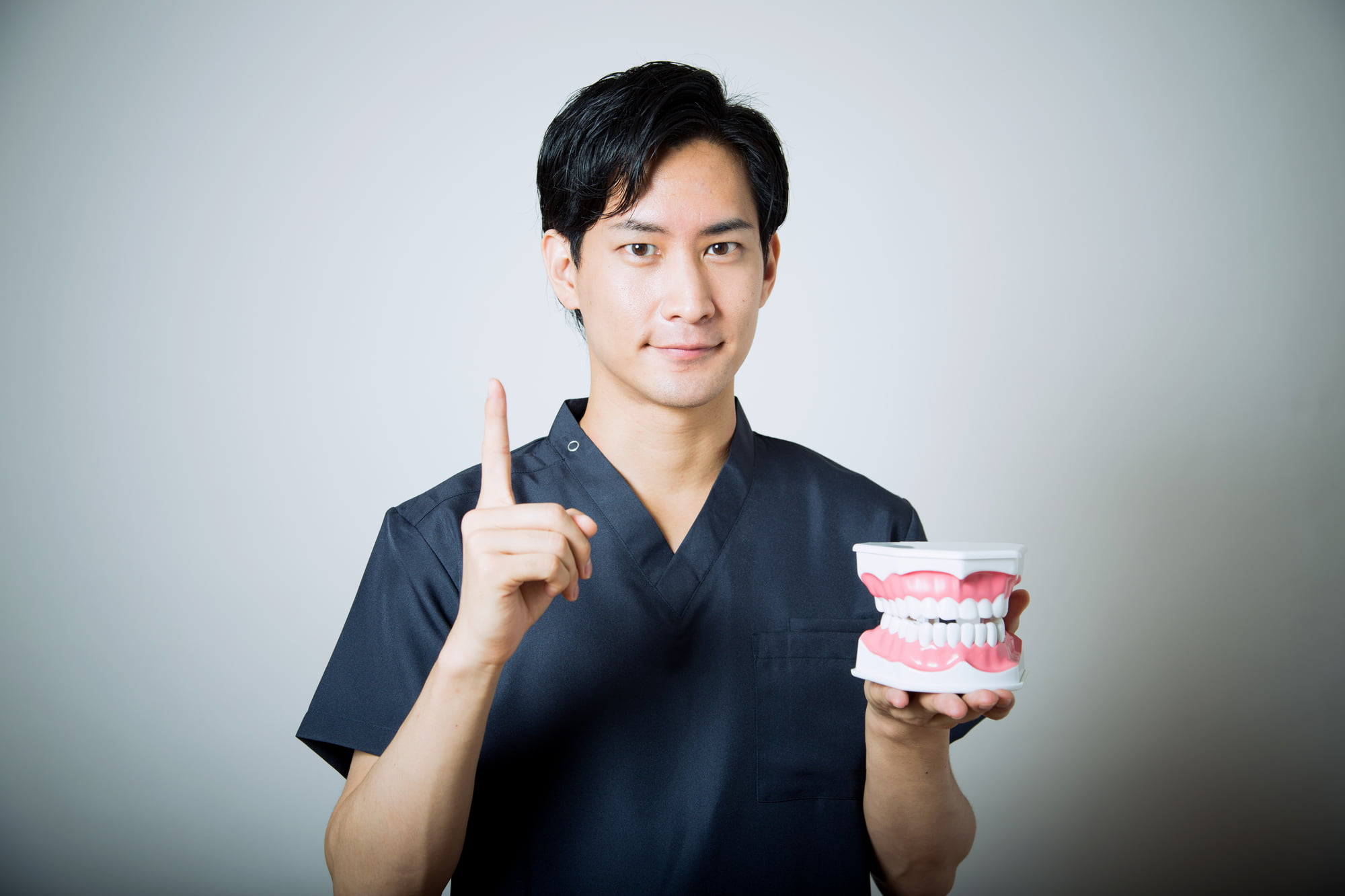 矯正治療後の後戻りについて説明する歯科医